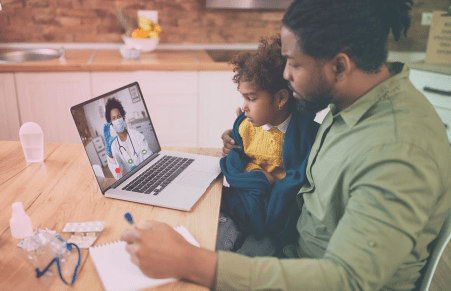 Man and child during a virtual doctor's appointment.