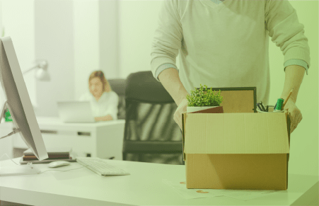 Leaving office worker packing a box of office supplies from desk