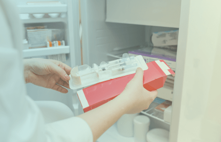Hands holding packaged syringes
