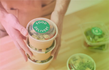 Hands holding sustainable packaged food containers