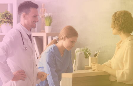 Doctor and front desk receptionist talking to a patient in waiting room