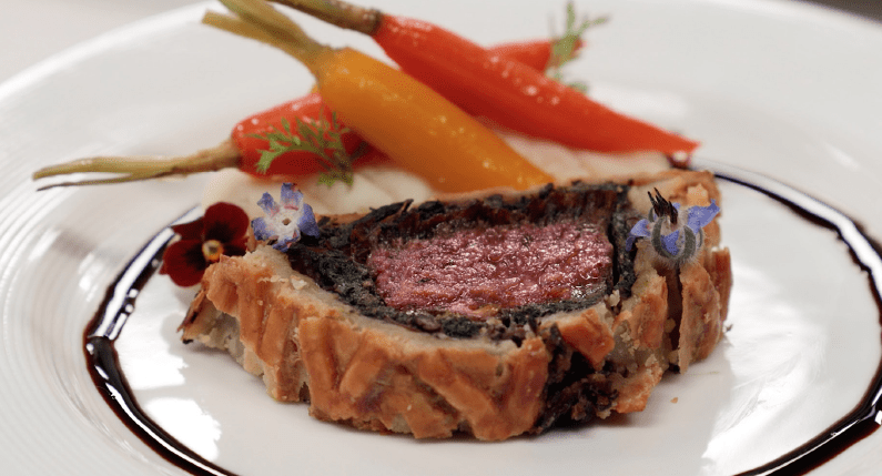 beef wellington with multiple colored carrots