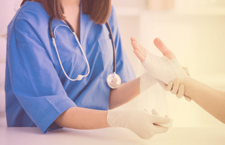 Nurse wrapping hand in guaze