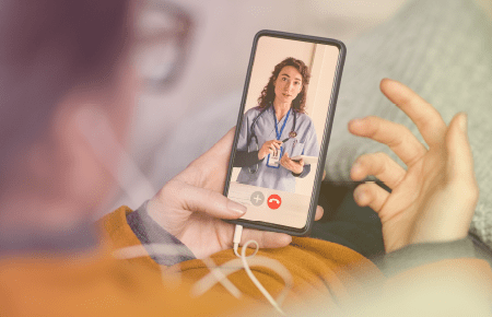 Smart phone displaying a video call with a nurse in blue scrubs