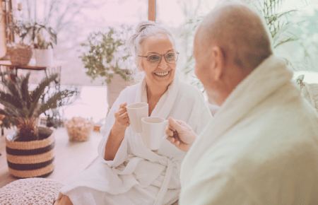 Elderly couple sitting and smiling while wearing white robes