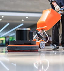 Janitor using a floor polisher in a hotel