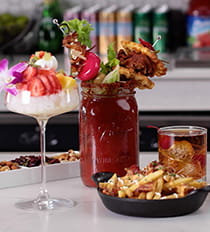 Display of tropical cocktail, bloody mary drink, dark mocktail and fries