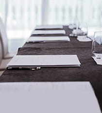 Table setting with notepad, pen, and glass cup