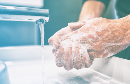man washing hands at sink
