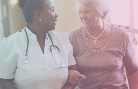 Smiling Nurse Helping Elderly Woman